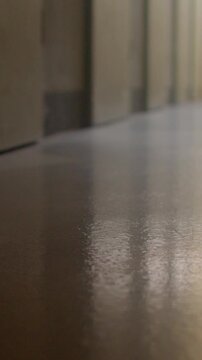 Low-angle corridor floor reflection with warm light and beige walls