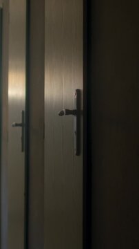 Dim school corridor with row of closed classroom doors and metal door-