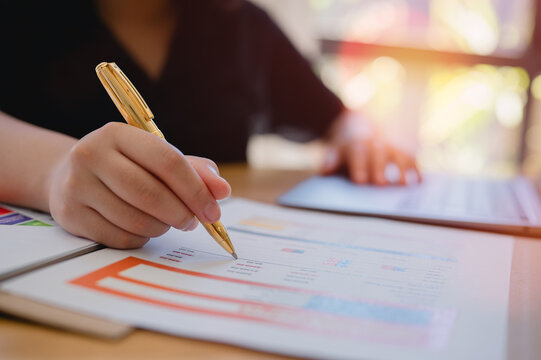 Executive Efficiency Businesswoman at Work using pen working with Documents data management, files and data management, bills expenses ,daily expenses, busy table with document and computer laptop
