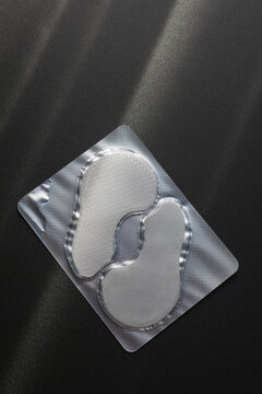 Under Eye Gel Patches in Sealed Blister Packaging on Dark Background