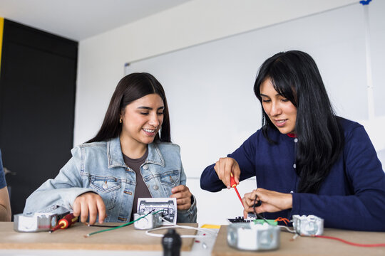 two latin american young women students in an electricity class or electrical circuits at university in Mexico