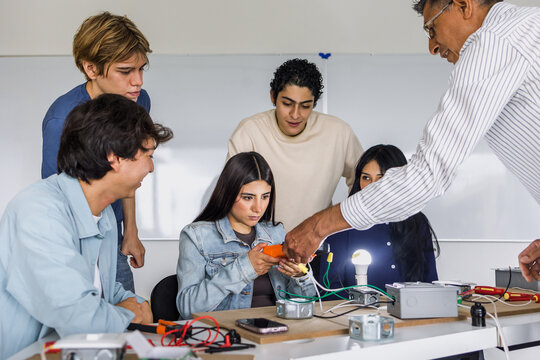 group of latin american students in an electricity class turning on a light bulb at university in Mexico