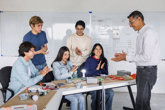 group of latin american students in an electricity class turning on a light bulb at university in Mexico
