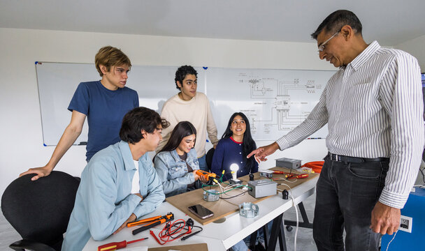 group of latin american students in an electricity class turning on a light bulb at university in Mexico