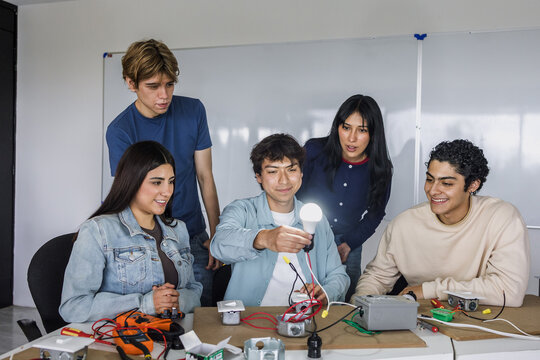 group of latin american students in an electricity class turning on a light bulb at university in Mexico