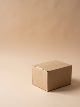 Photorealistic Brown Cardboard Packaging Box on a Warm Beige Surface with Soft Natural Light, Minimalist E-Commerce and Sustainable Packaging Concept
