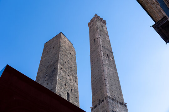 Low angle view of the Asinelli and Garisenda medieval towers against a blue sky in Bologna, Italy