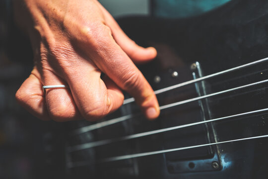 Hand Plucking Bass Guitar Strings Near the Pickup