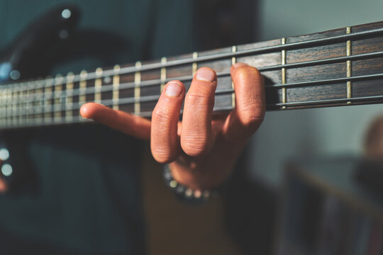 Close-Up of a Hand Fretting a Bass Guitar Neck