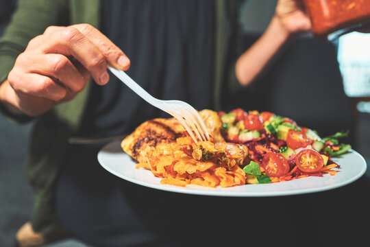 Fork Picking Up Kimchi from a Plate of Chicken and Salad