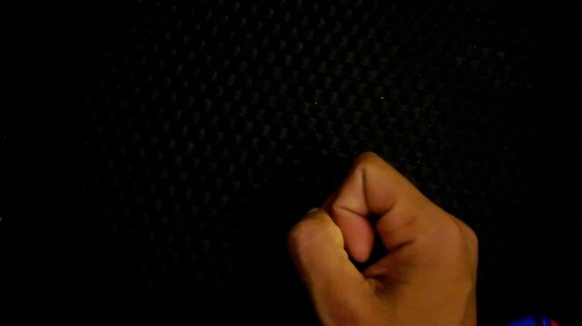 Toddler and parent hands holding plush monkey baby rattle toy on dark background