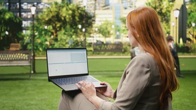 Woman analyzes binary code on laptop in city park