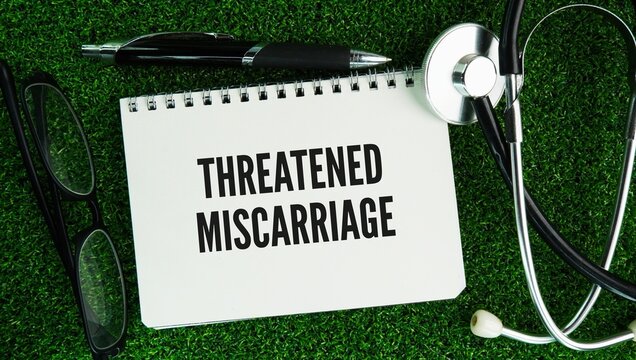 Stethoscope and paper with the word Threatened Miscarriage is a common condition where vaginal bleeding and mild cramping occur during the first 20 weeks of pregnancy, while the cervix remains closed 