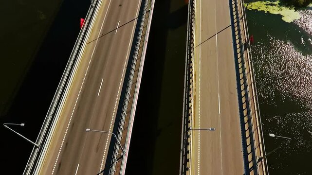 Dual highway bridges over river. Aerial tilt up reveals autumn road landscape.
