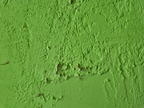 Bright green textured plaster wall background with rough uneven surface, raised ridges, natural imperfections, and subtle shadows