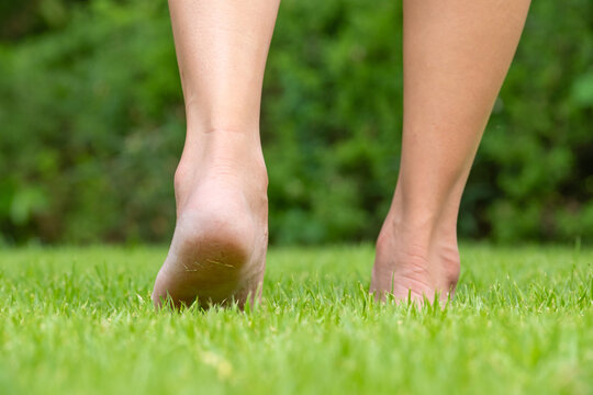 Leg of woman is on the ground. She is about to walk down the grass to exercise in the morning. Health and Relaxation Concepts	