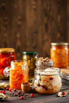 Fermented preserved vegetables food concept. Glass jars with fermented, pickled and canned vegetables  on  kitchen table. Conservation of farm organic seasonal harvest. Healthy homemade food