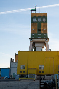 Mine headframe tower with a black and green flag flying at half-mast, symbolizing mourning after a tragic mining accident.