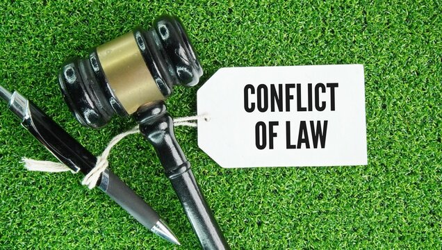 Judge's gavel and paper tag with the word Conflict of laws also known as private international law is the set of legal rules a court uses to handle a case, contract, or dispute that involves more than