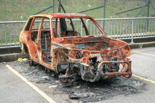 Burned Out Car Wreckage in Parking Lot by the roadside, abandoned.