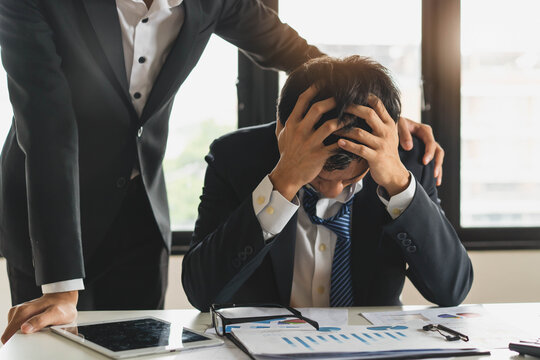 Colleague touch shoulder encouraging young businessman after work failure.