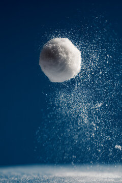 Snowball Floating Quietly above the Snow with Fine Ice Particles Suspended in Moody Blue Winter Atmosphere