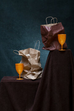 Two crumpled paper bags on the table and two colored glasses.