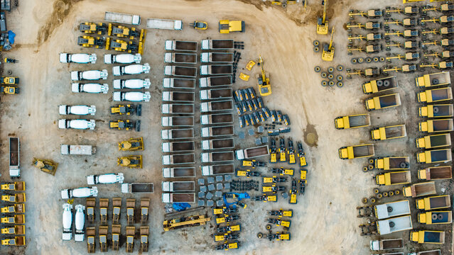 Aerial view of trucks and heavy machinery in a construction yard.