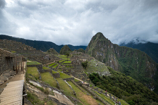 Inca citadel in Andes mountain landscape with green terrace and peak