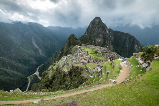 Ancient stone citadel ruins high in misty mountain valley landscape