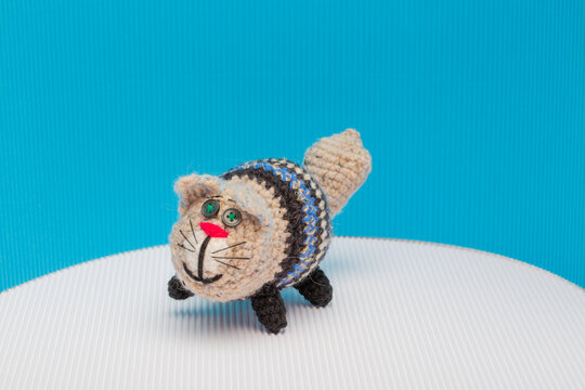 Cat crocheted from yarn against a colorful background