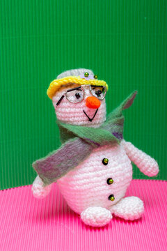 Snowman knitted from yarn, set against a colorful background
