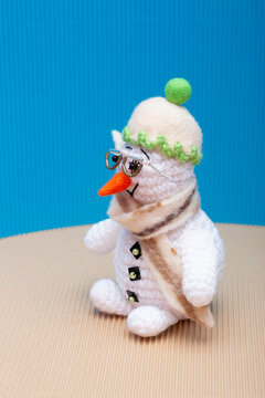 Snowman knitted from yarn, set against a colorful background