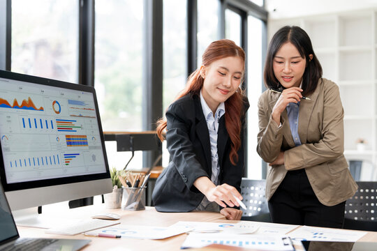 Asian Businesswomen Standing and Discussing Strategy in Office Meeting