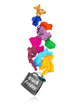 Flying colorful clothes falling out of a paper shopping bag, creative Black Friday commercial sales levitation concept isolated on white background.