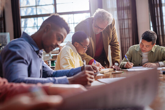 Academic support for student studying and writing at a library table