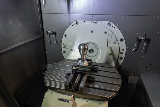 Interior of a five axis CNC milling machining center with rotary table and precision machined component, showcasing advanced multi axis machining technology and high accuracy metal manufacturing.