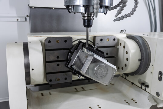 Interior of a five axis CNC milling machining center with rotary table and precision machined component, showcasing advanced multi axis machining technology and high accuracy metal manufacturing.