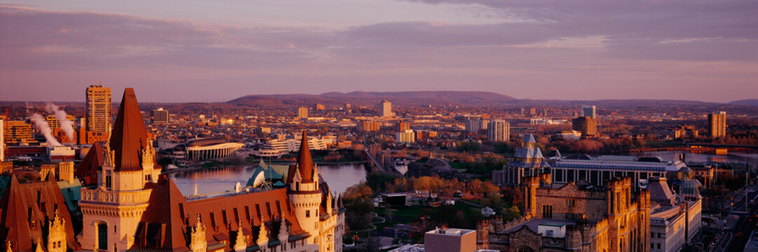 Cityscape with river, bridge, and urban buildings at sunset