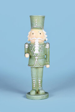 Mint green Christmas nutcracker decoration on blue background