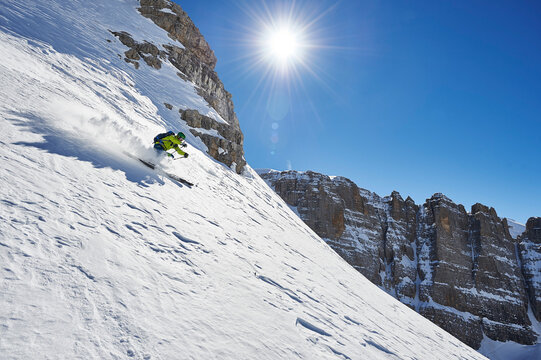 Two men skiing down snowy slope in the Dolomites, Trentino, italy