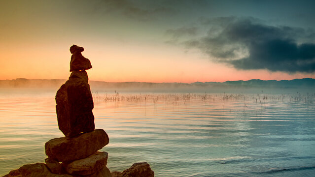 Stone men at sunrise on Lake Starnberg in Bernried, Bavaria, Germany