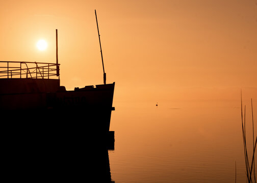 Silhouette of a museum ship at sunrise on Lake Starnberg in Bavaria