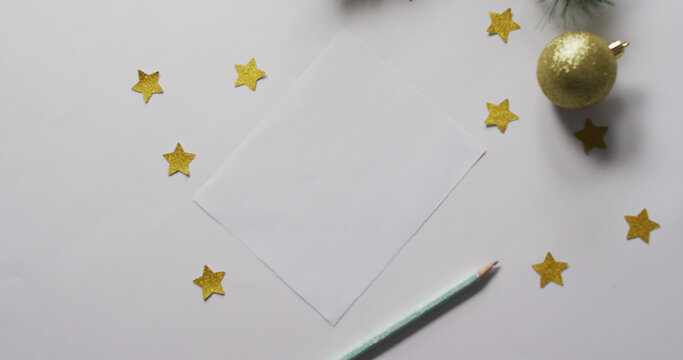 Image of christmas decorations and stars with white card on white background