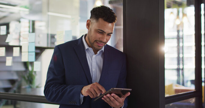 Portrait of businessman using tablet smiling looking at camera