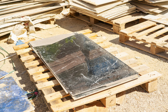 Stacks of ceramic tile waste and leftovers on wooden pallets outdoor