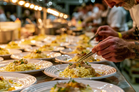 Chef plating fresh pasta dishes in a busy professional restaurant kitchen with spaghetti