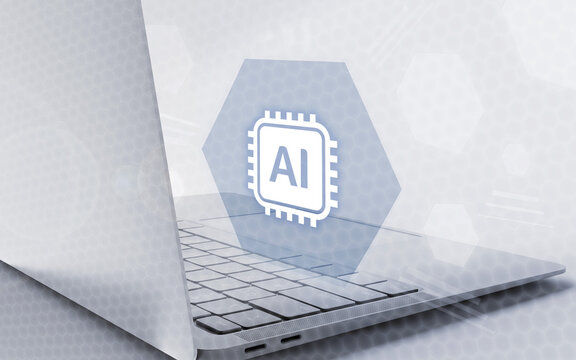 Una computadora port&aacute;til moderna con un holograma digital que muestra un icono de procesador con las letras AI sobre un fondo tecnol&oacute;gico abstracto y brillante.