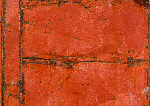 Close-up of Weathered Red Metal Surface with Rust and Peeling Paint