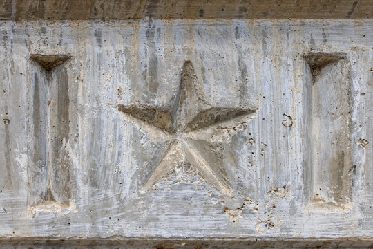 Embossed Star on Textured Concrete Surface